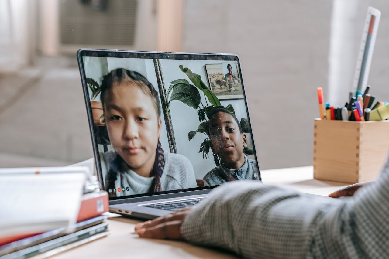 Children participating in a virtual learning session on a laptop, showcasing remote education during isolation.